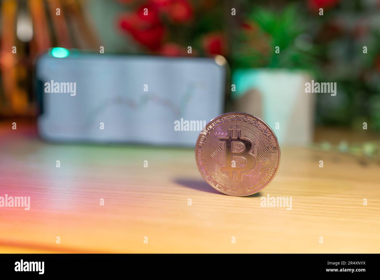 Moneda de oro de Bitcoin delante de la tabla de precios de criptomonedas - concepto y gráfico de criptomonedas - Sistema financiero y clase de inversión Foto de stock