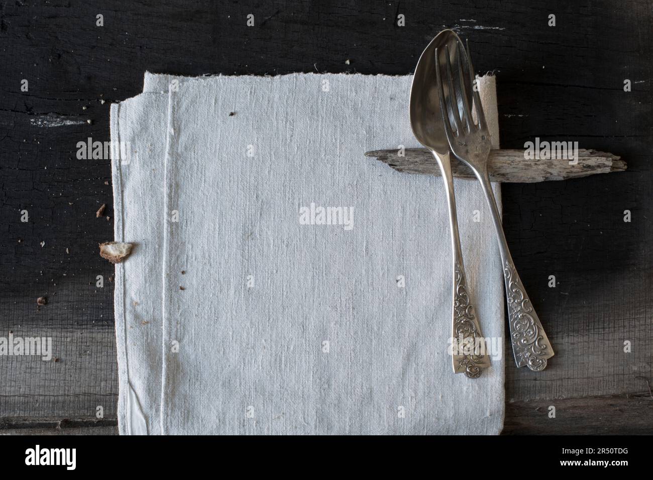 Tenedor y cuchara vintage en pieza de madera como soporte para cubiertos Foto de stock