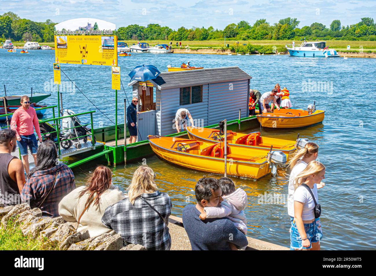 Los turistas hacen cola para alquilar barcos en el río Támesis en Windsor en un día soleado a principios del verano. Foto de stock