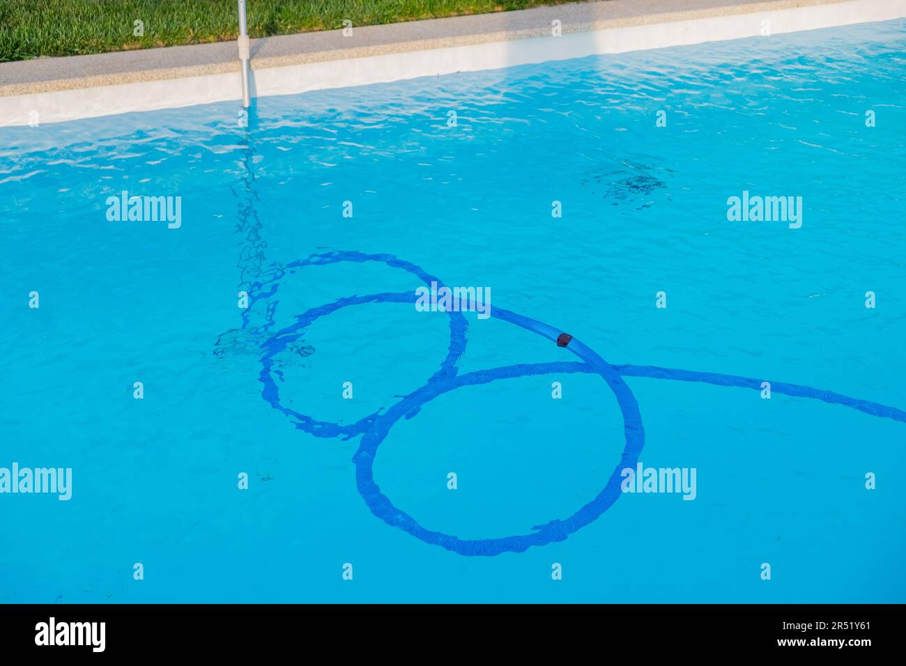 tubo de aspiradora de piscina en una piscina llena de agua Foto de stock