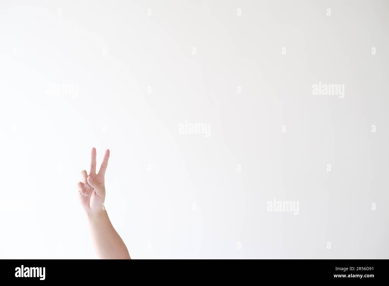 La mano de un hombre con símbolo de paz o gesto sobre un fondo blanco aislado Foto de stock