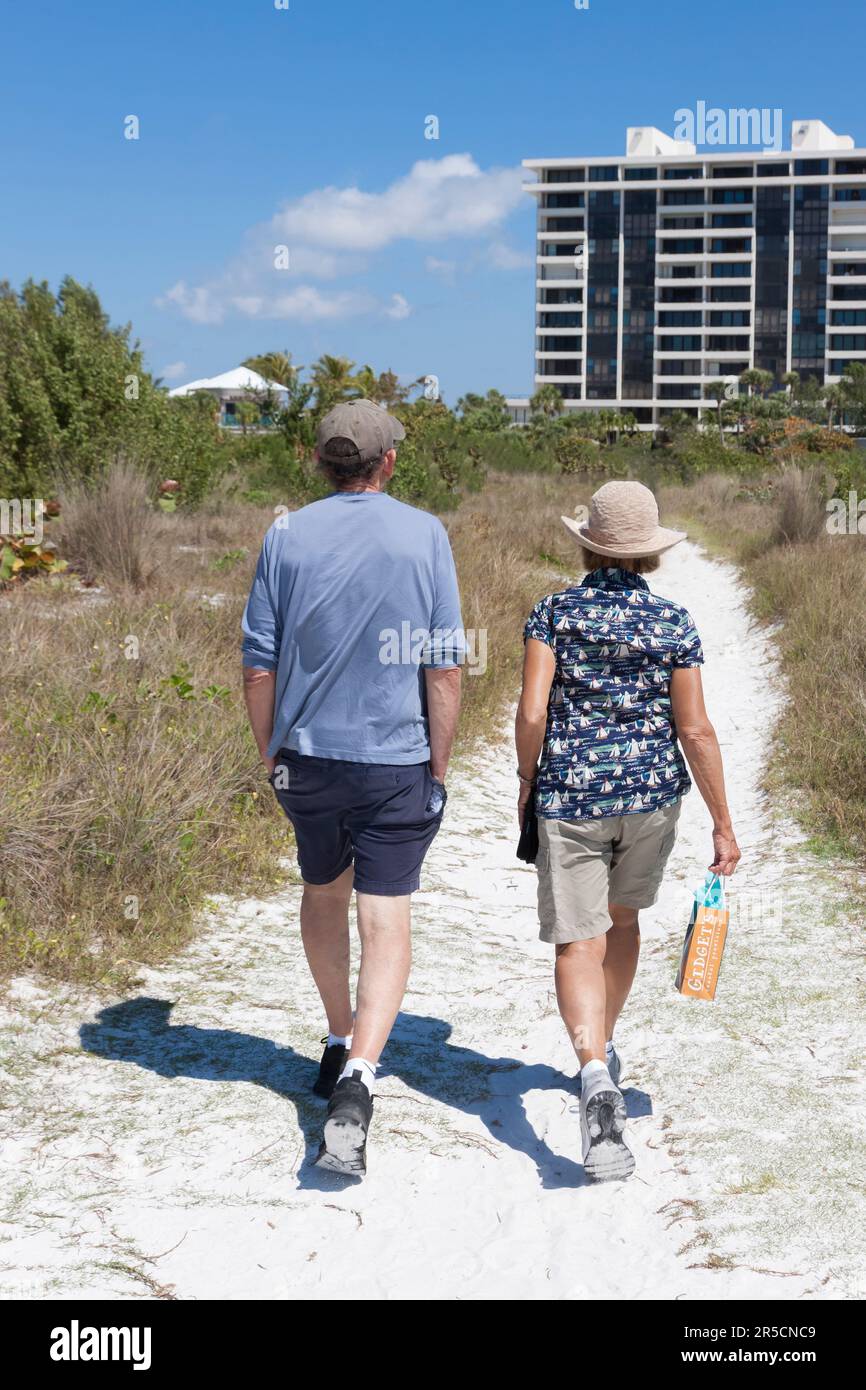 Pareja casada, de vacaciones, caminando por el camino de la playa en Siesta Key, Sarasota, Florida, Estados Unidos. Foto de stock