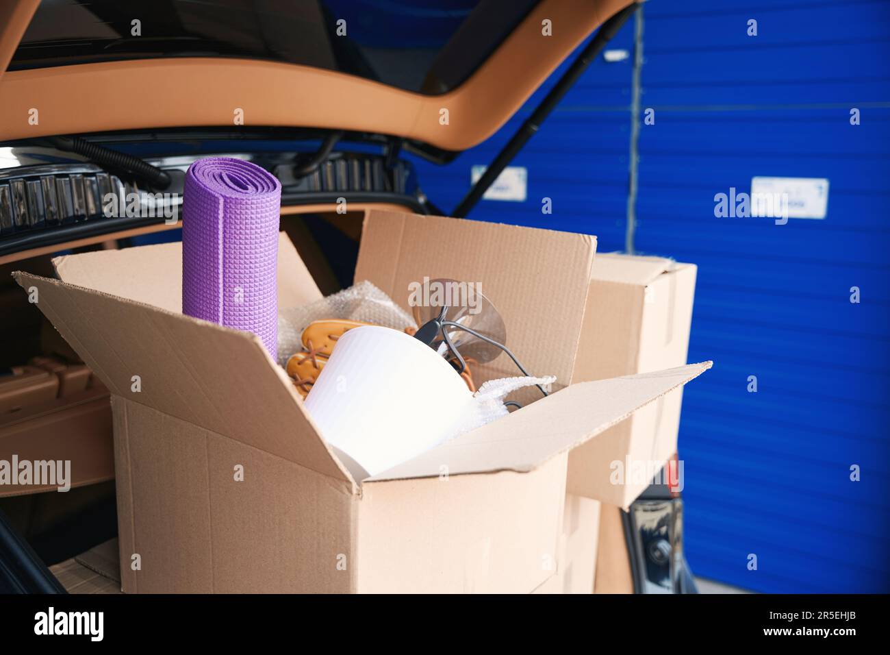 Cajas de cartón con cosas en el maletero del coche en el almacén Fotografía  de stock - Alamy