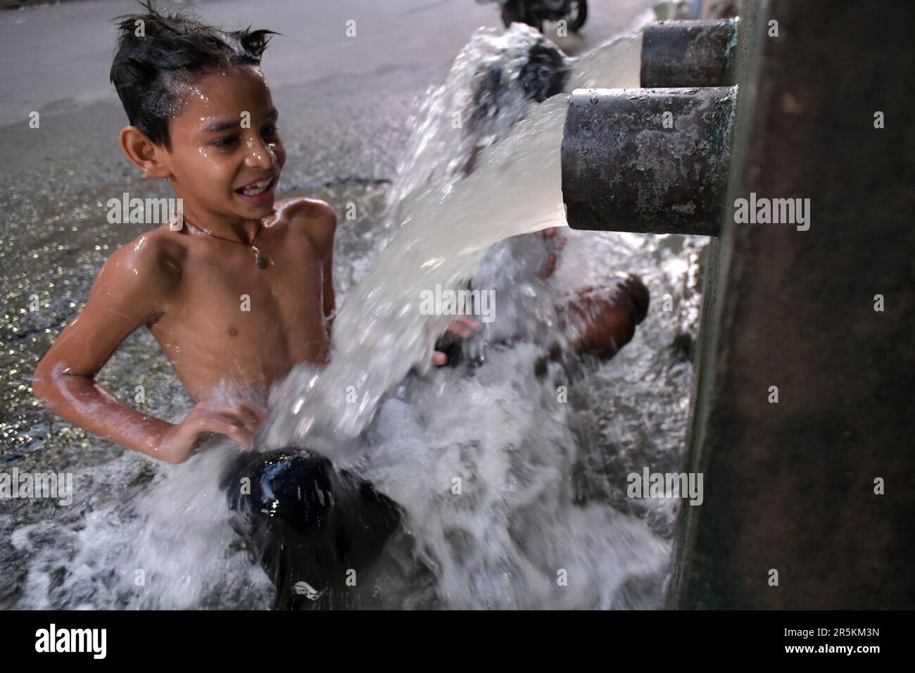 Kolkata, India. 04th de junio de 2023. Un niño se está bañando en un grifo municipal al lado de la carretera en un caluroso día de verano. (Foto de Dipayan Bose/SOPA Images/Sipa USA) Crédito: SIPA USA/Alamy Live News Foto de stock