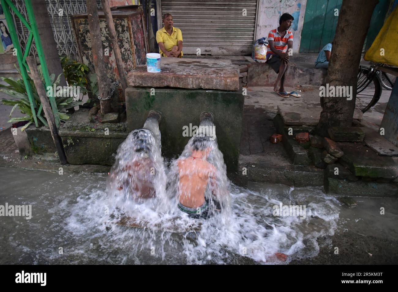 Kolkata, India. 04th de junio de 2023. Dos niños se bañan en un grifo municipal al lado de la carretera en un caluroso día de verano. (Foto de Dipayan Bose/SOPA Images/Sipa USA) Crédito: SIPA USA/Alamy Live News Foto de stock