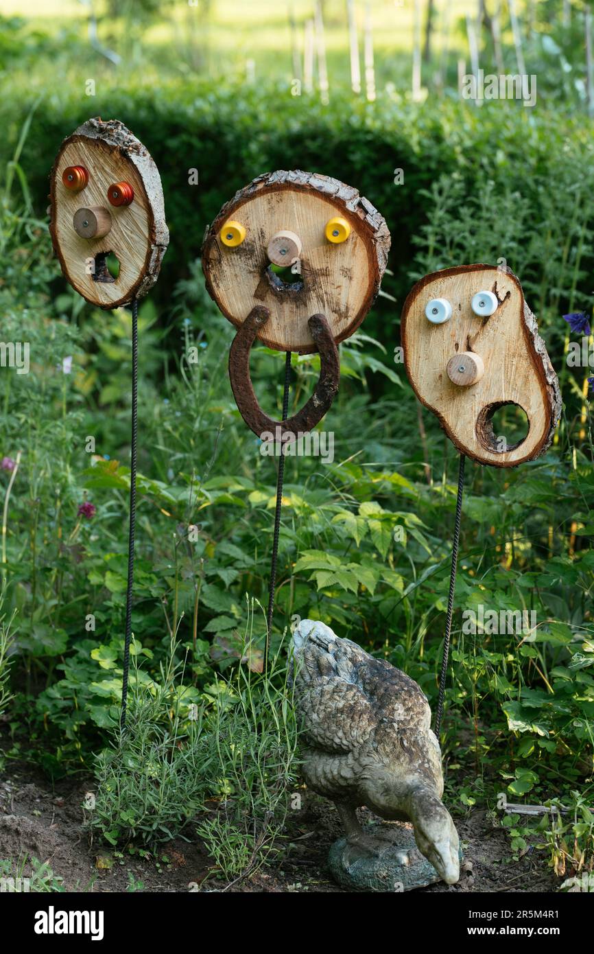 Disco de árbol con una cara en una barra de acero como decoración de jardín. Foto de stock
