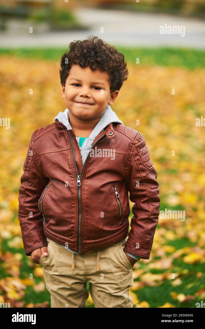 Retrato al aire libre del otoño del muchacho africano lindo, llevando la  chaqueta de cuero marrón, niño que se divierte en parque Fotografía de  stock - Alamy