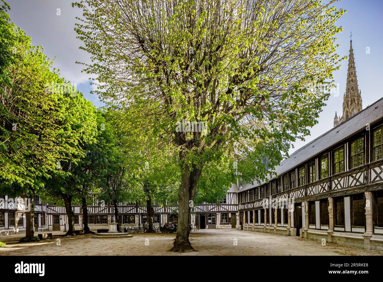 Francia, Seine-Maritime, Rouen, Aître Saint-Maclou, antiguo osario creado durante la Gran Peste Negra de 1348, vista del patio, después de la salida de la escuela de Bellas Artes y reciente renovación de 2018 a 2022, aguja de la iglesia de Saint-Maclou en el fondo Foto de stock