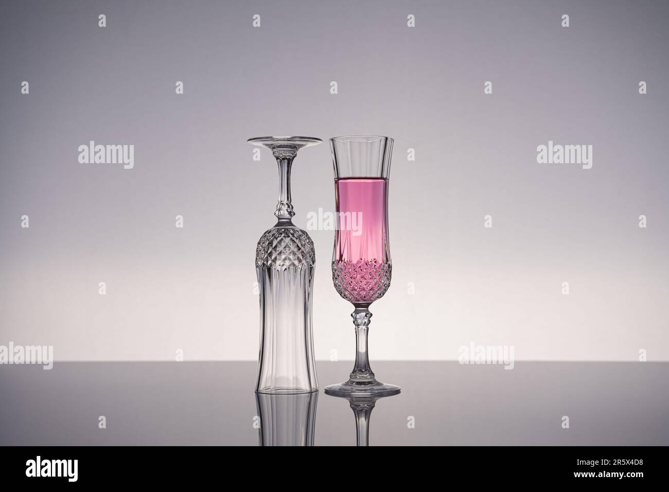 Copa de champán, flauta de champán, aislado en superficie gris brillante con fondo gris. Foto de stock