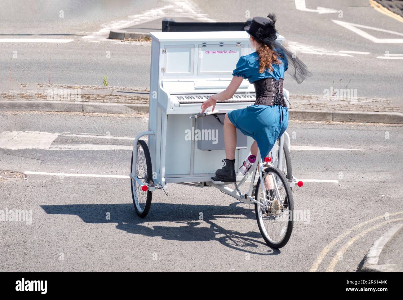 Chloe Marie Aston, una busker en el suroeste de Inglaterra montando su Piano Bike única de un lugar a otro. Foto de stock