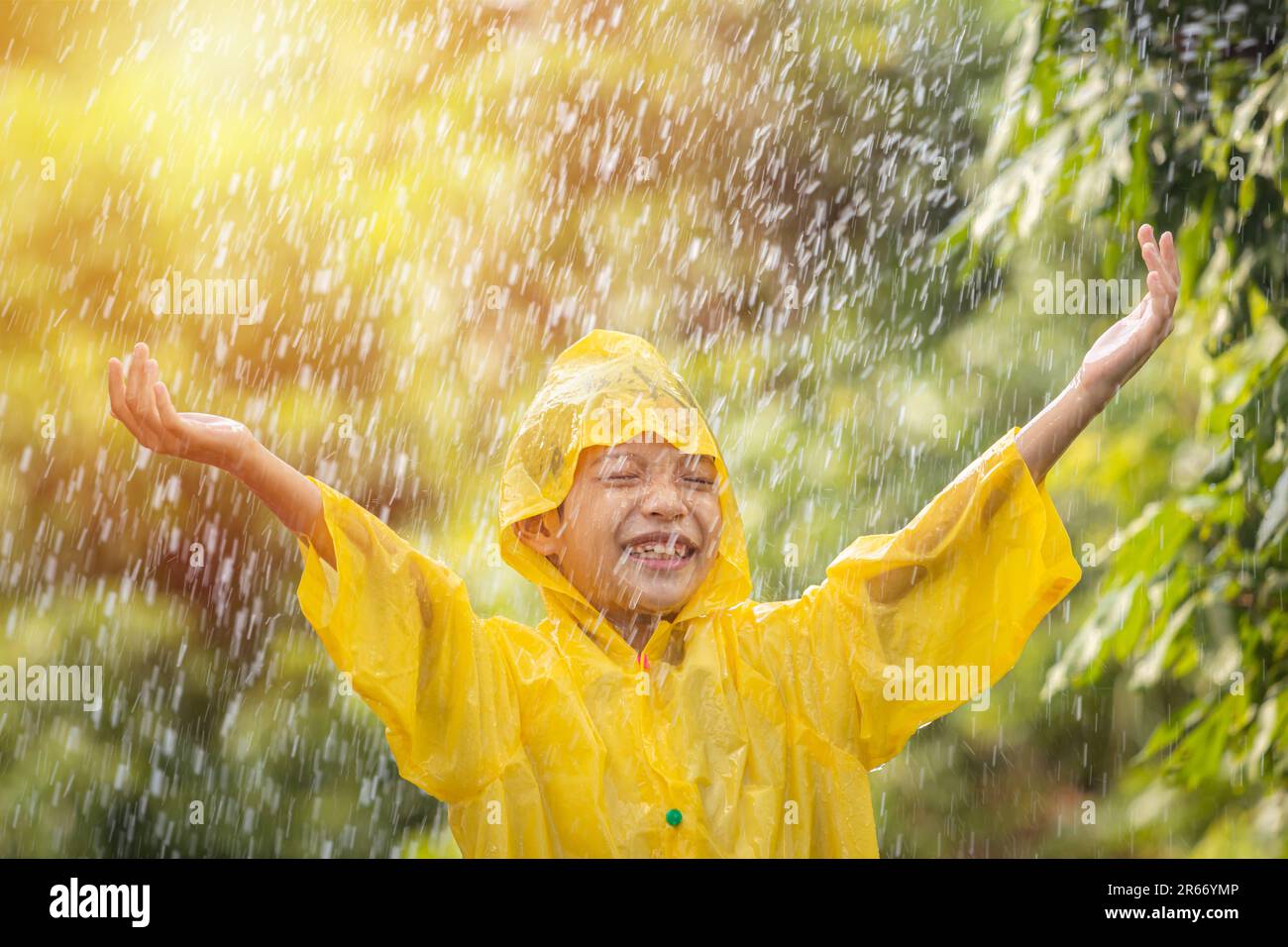 Una joven con chubasquero amarillo y paraguas se está divirtiendo mientras  camina por la ciudad en un ambiente tranquilo bajo la lluvia. Paseo,  lluvia, ciudad Fotografía de stock - Alamy