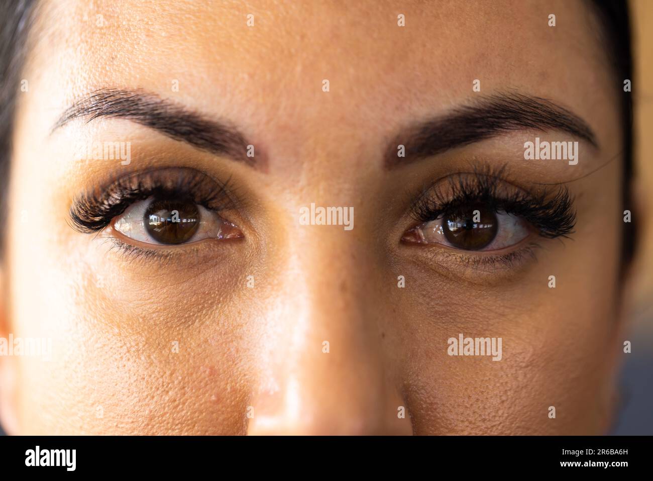 Retrato de primer plano de la mujer joven caucásica confiada con los ojos marrones mirando a la cámara en el club de salud Foto de stock