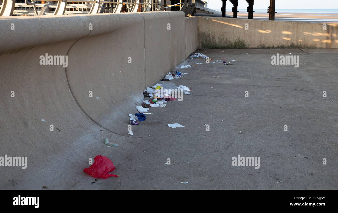 Una vista a lo largo de un paseo marítimo de montones de basura dejados por los turistas el día anterior Foto de stock