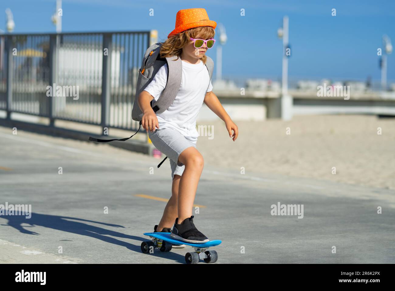 Niños deportivos de verano con skateboard. Niño montando skateboard en la  carretera. Niño practicando skateboard. Los niños aprenden a montar en  patineta en un parque Fotografía de stock - Alamy