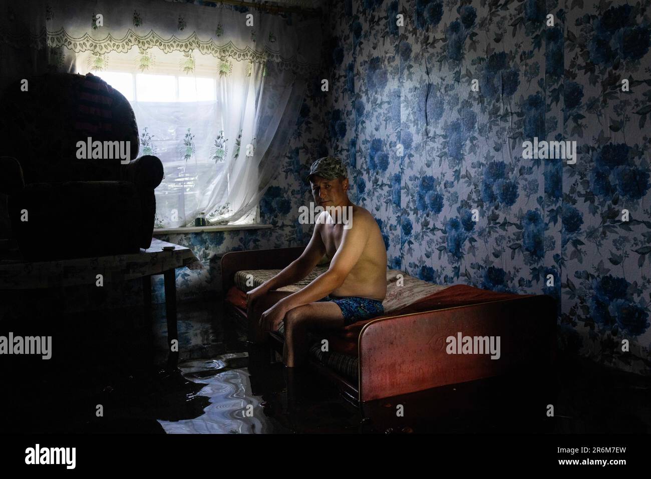 Afanasiivka, Mykolaiv Oblast, Ucrania. 9th de junio de 2023. El guardia de seguridad Vitali, de 33 años, posa para un retrato dentro de su casa inundada en las aguas de la inundación en Afanasiivka, Ucrania, el 9 de junio de 2023. La región se está inundando desde el río Inhulets después de que la presa Nova Kakhovka fue explotada. (Imagen de crédito: © Daniel Carde/ZUMA Press Wire) ¡USO EDITORIAL SOLAMENTE! ¡No para USO comercial! Foto de stock