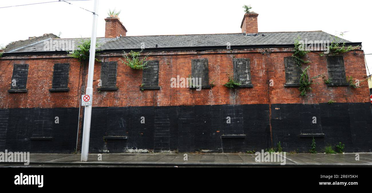 Un antiguo edificio abandonado de fábrica de ladrillo rojo cerca del río Liffey en Dublín, Irlanda. Foto de stock