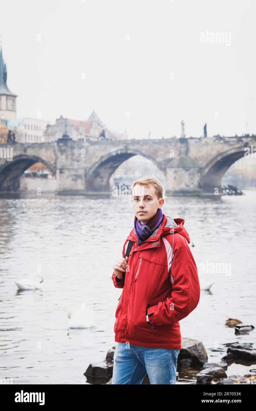 Turista masculino en chaqueta roja, jeans azules en el terraplén de Praga  Fotografía de stock - Alamy