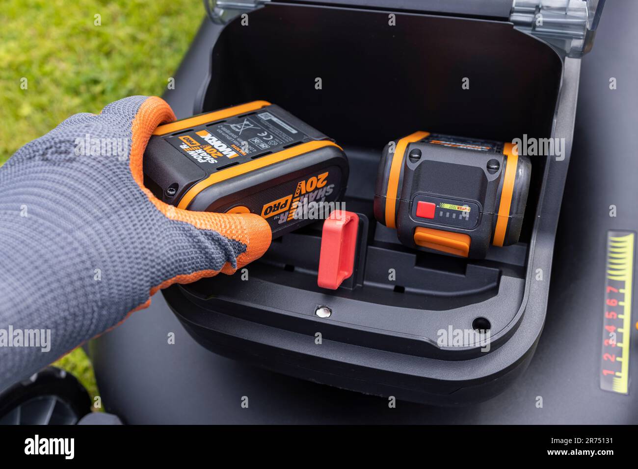 Mano inserta la batería WORX recién cargada 20V 4,0Ah en una nueva  cortadora de césped sin cable, WORX NITRO WG749E - 40 V, compartimento de  la batería, detalle, corte de césped, jardín