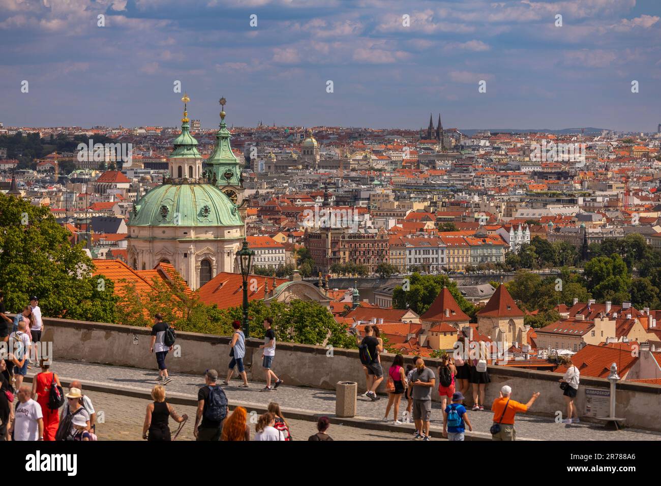 PRAGA, REPÚBLICA CHECA, EUROPA - Los turistas caminan frente a la cúpula de San. La iglesia de Nicolás, una iglesia barroca en la Ciudad Menor de Praga, y vista de cit Foto de stock