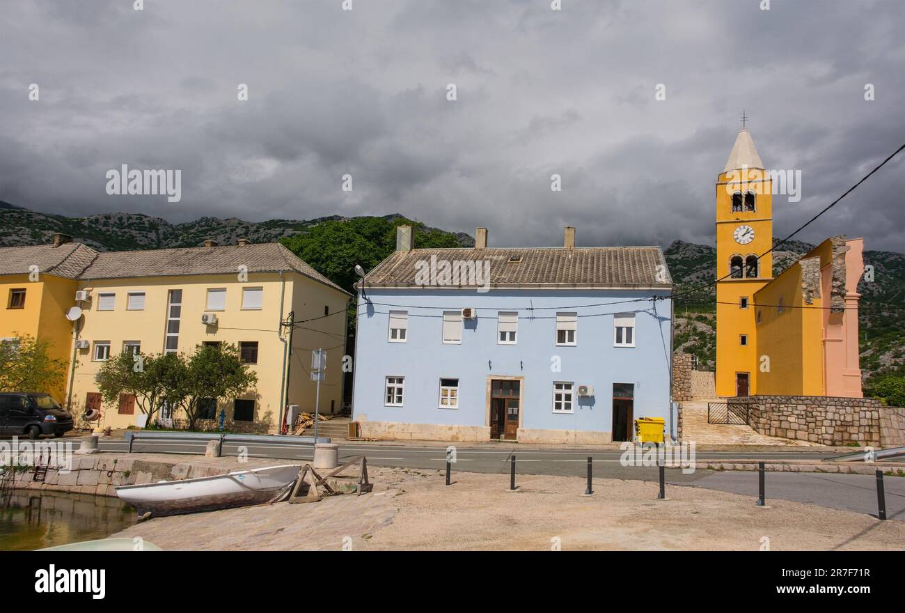 El pueblo de Karlobag en el condado de Lika-Senj en la costa adriática de Croacia, finales de la primavera. A la derecha, iglesia del siglo XVIII de San Carlos de Borromeo Foto de stock