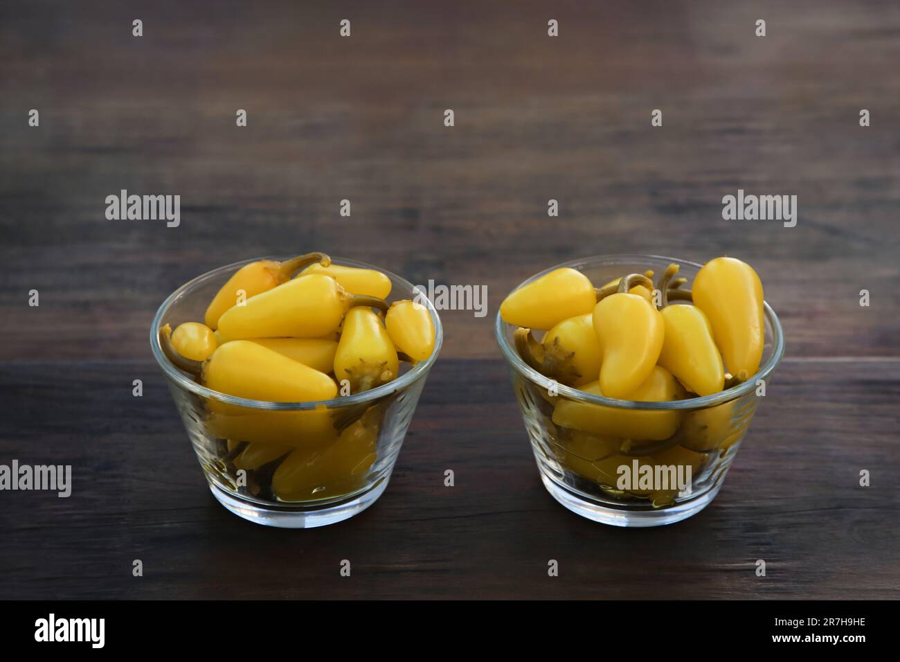 Pimientos jalapeño amarillos en escabeche sobre mesa de madera Foto de stock