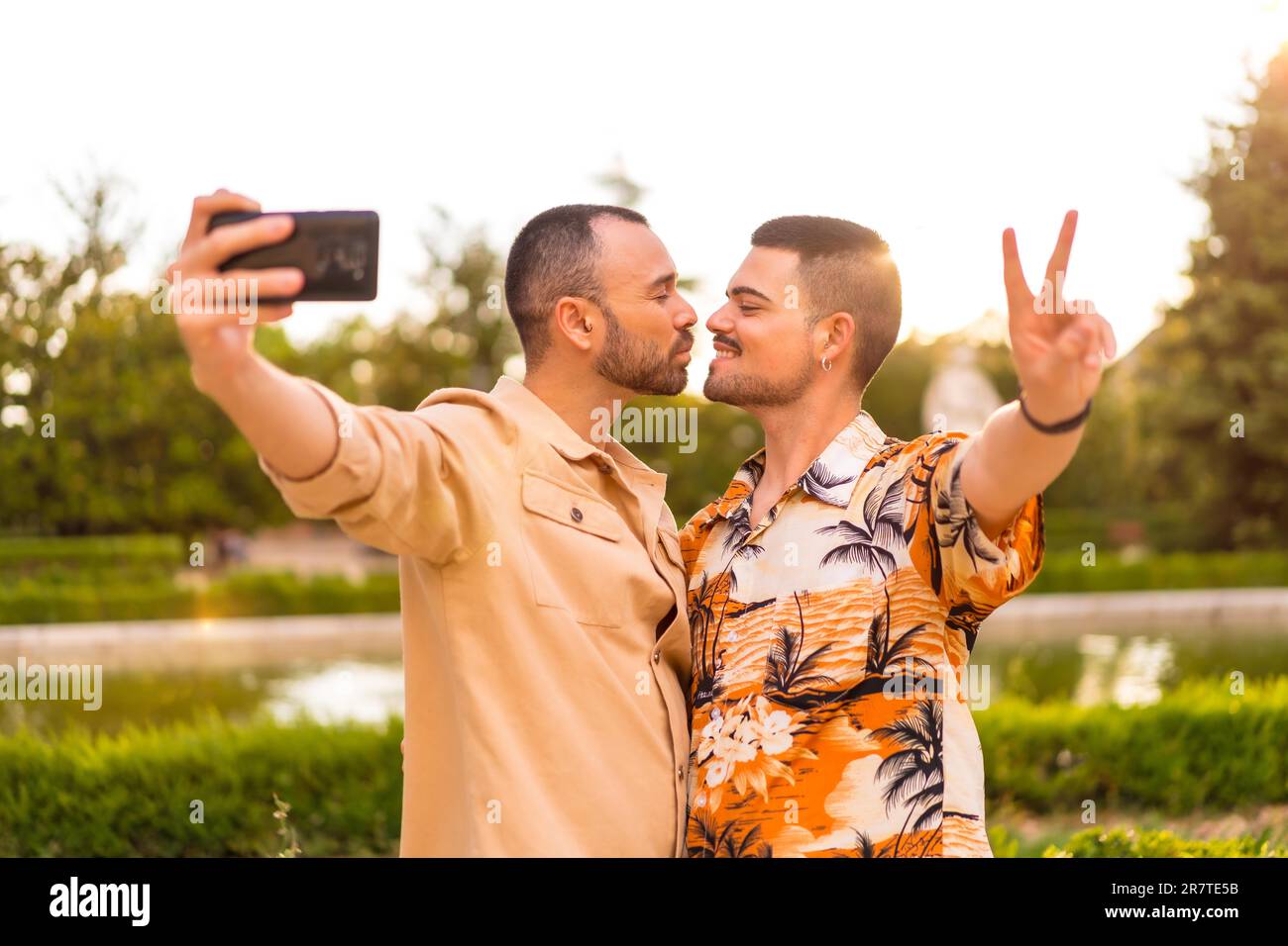 Pareja Homosexual Tomando Un Selfie Y Besándose Al Atardecer En Un Parque De La Ciudad 