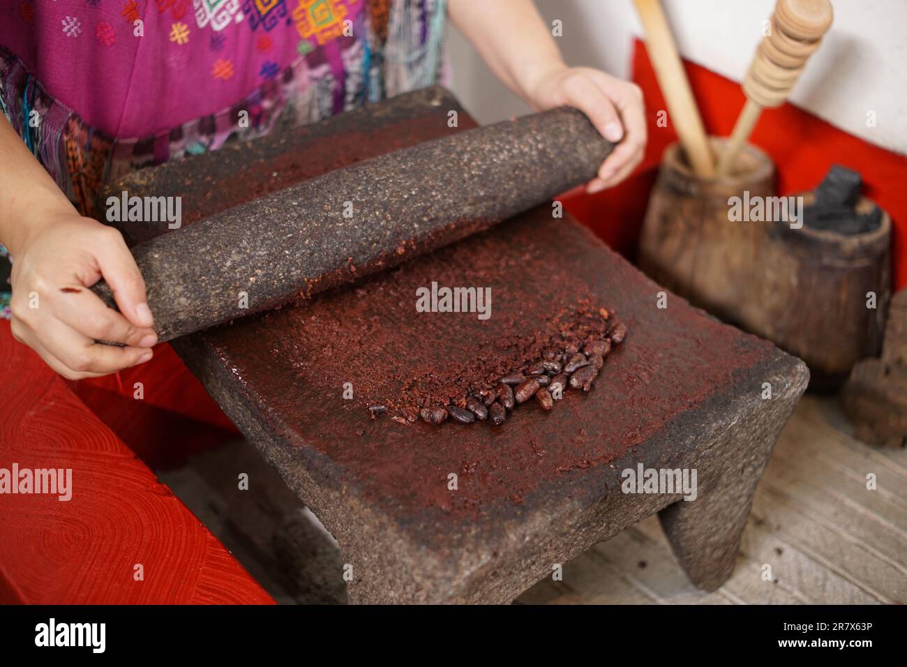 Mujer maya guatemalteca haciendo chocolate con piedra de molienda tradicional Foto de stock