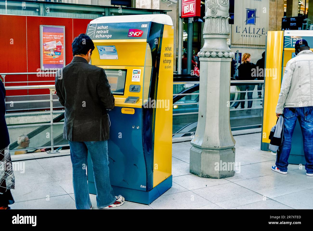 París, Francia- Estación de tren Gare du Nord, hombre que compra el billete de tren de la máquina expendedora, ordenador de pantalla táctil, interior, para el tren Eurostar Foto de stock