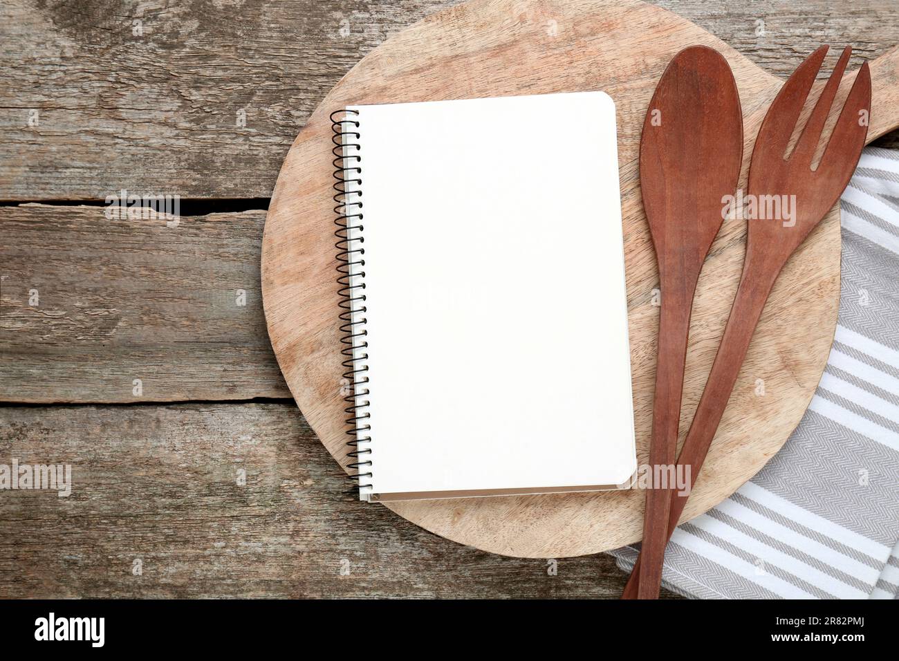 Libro de recetas en blanco y utensilios de cocina en la vieja mesa