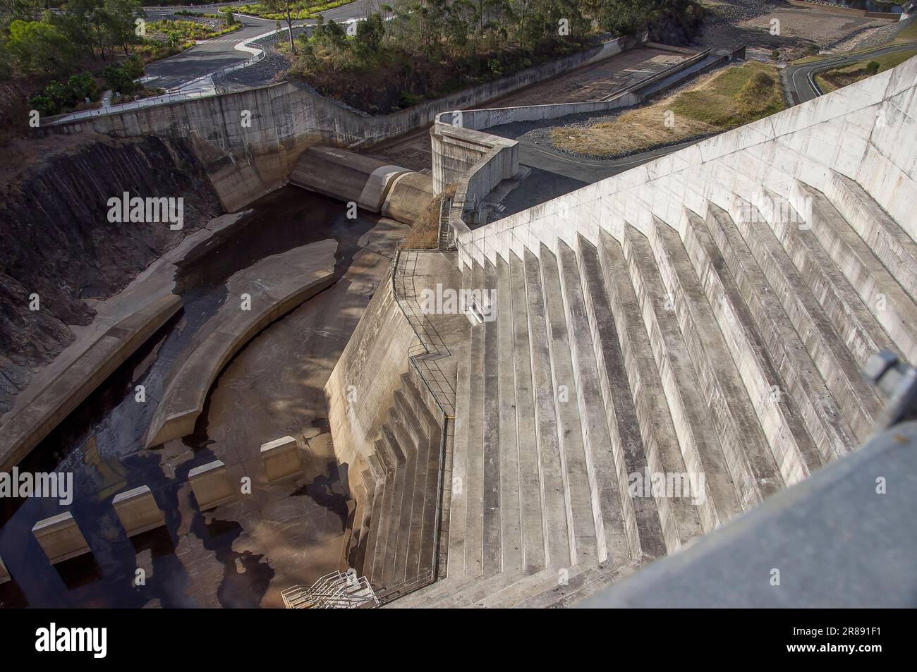 Vista desde la parte superior del vertedero escalonado de hormigón de la presa Hinze en Advancetown, SE Queensland, Australia. Ingeniería de mitigación de inundaciones, Gold Coast hinterland. Foto de stock