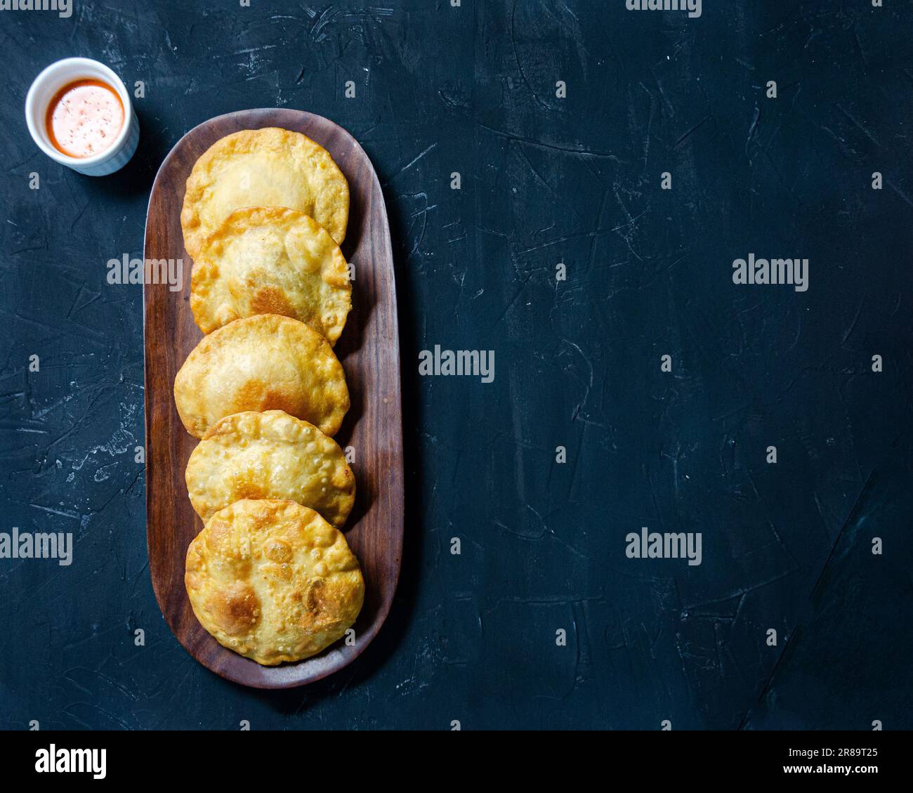 Pastelito comida tradicional venezolana en fondo oscuro, vista plana Foto de stock