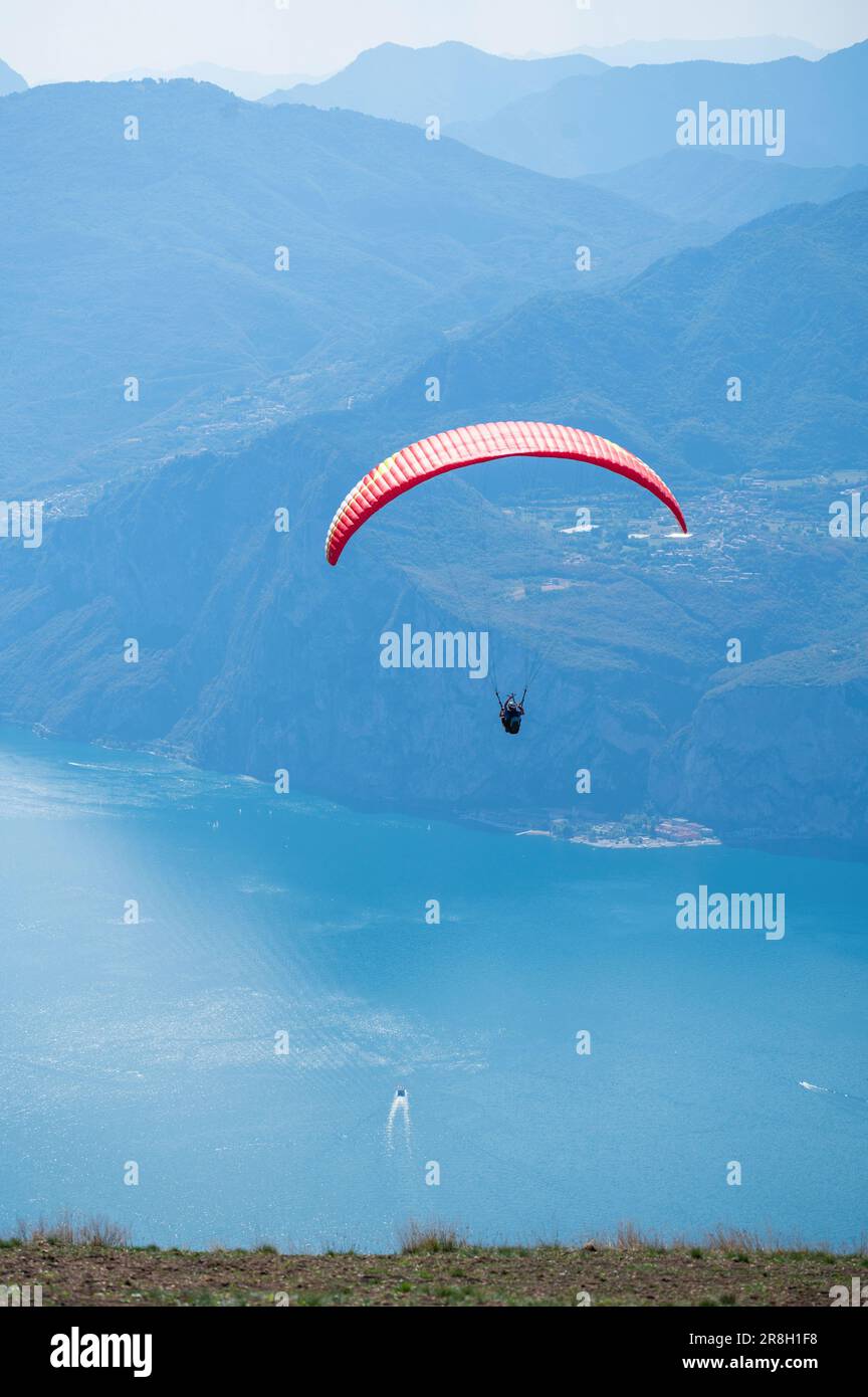 Los parapentes saltan desde la cima del Monte Baldo, hacia Maclesine y el lago de Garda en Italia Foto de stock