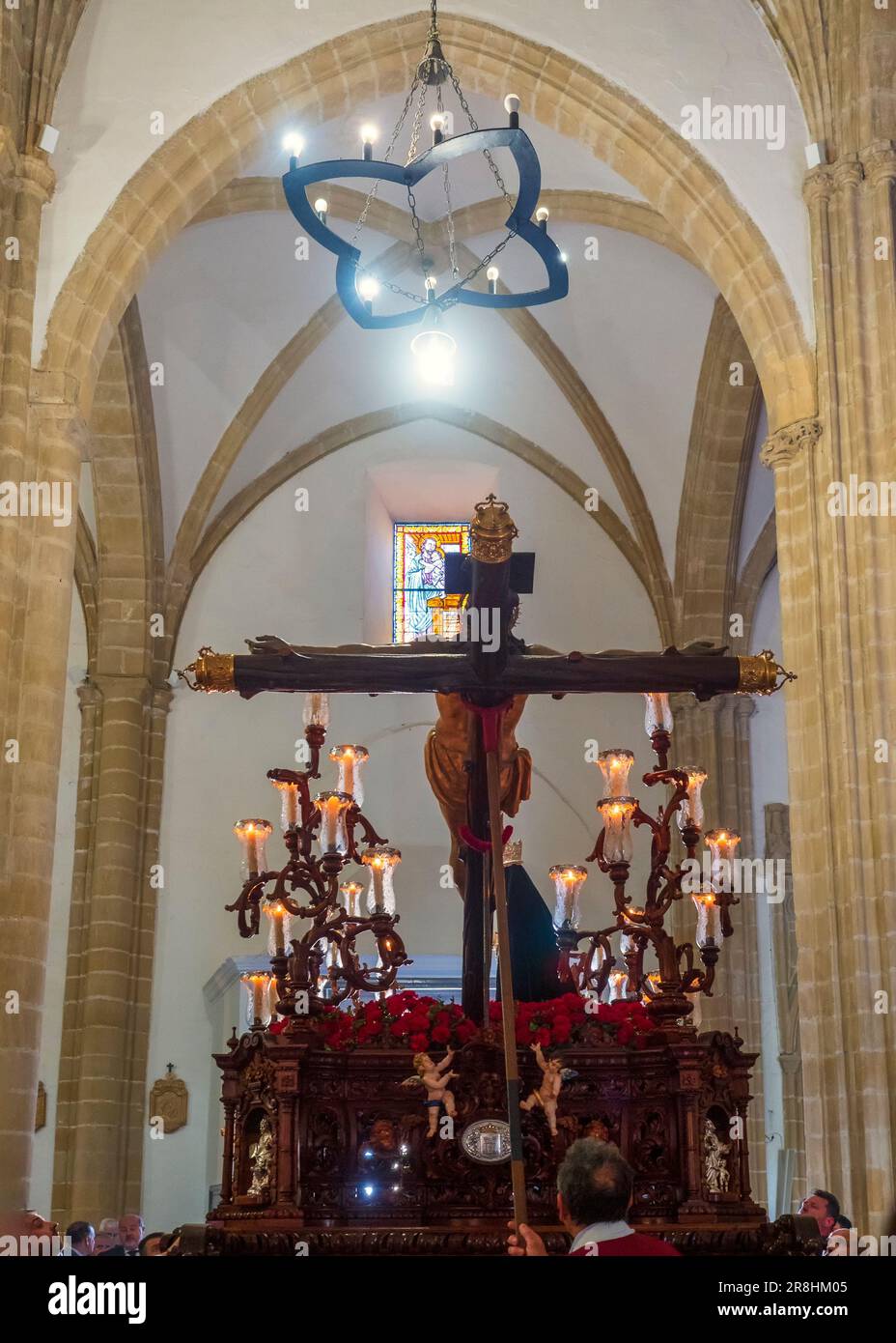 El trono con la figura de Jesucristo en la cruz junto a la Virgen María, dejando la iglesia durante la celebración de la Semana Santa en Baeza. Foto de stock