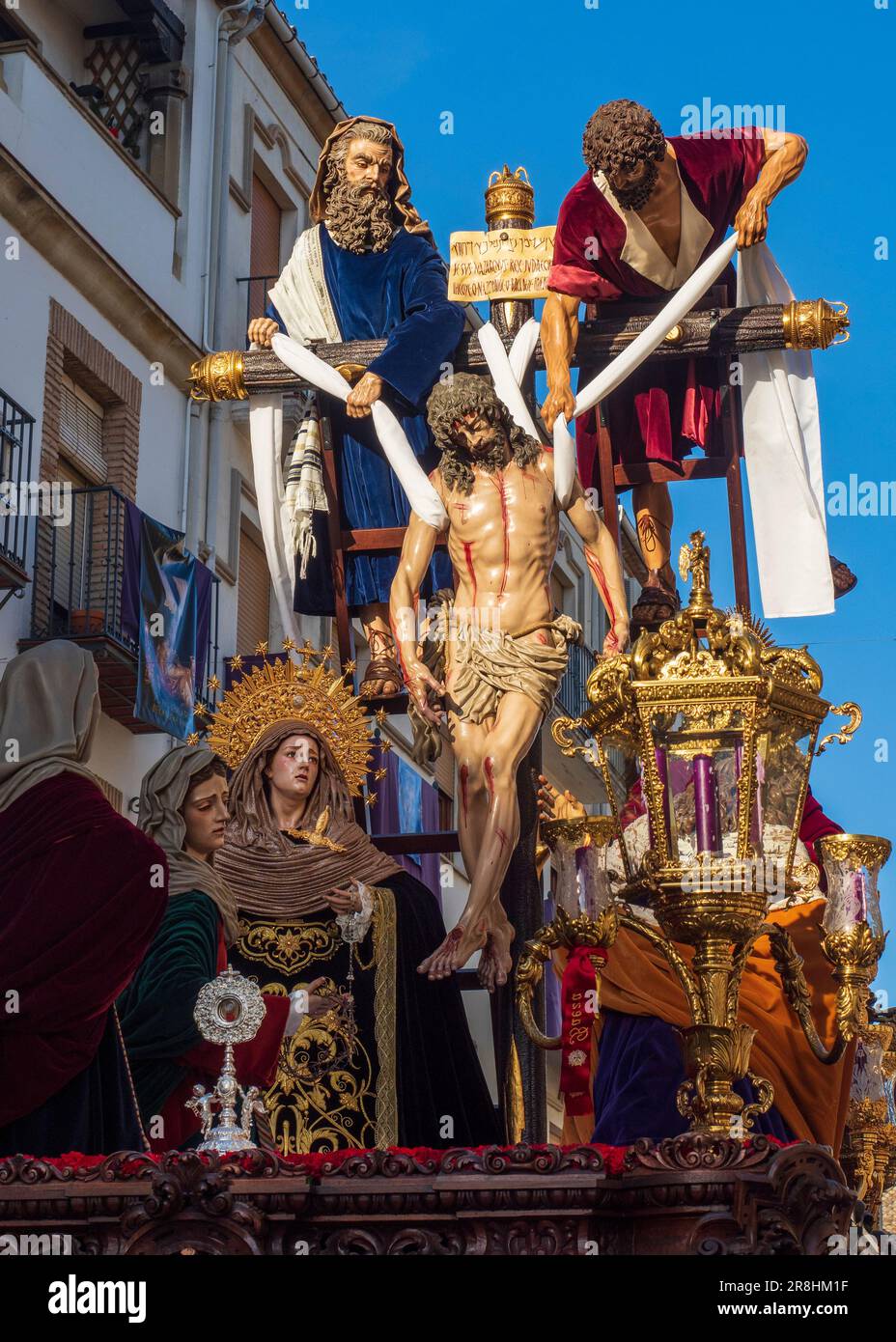 El trono con la figura de Jesucristo en la cruz junto a la Virgen María, dejando la iglesia durante la celebración de la Semana Santa en Baeza. Foto de stock