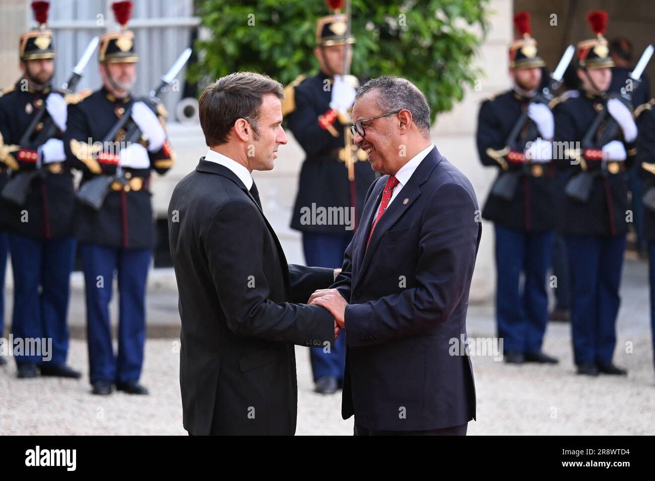 El presidente francés Emmanuel Macron y su esposa Brigitte Macron saludan al Director General de la Organización Mundial de la Salud, Tedros Adhanom Ghebreyesus, a su llegada para una cena oficial en el Palacio del Elysee, al margen de la Cumbre del Nuevo Pacto Financiero Mundial, en París, el 22 de junio de 2023. Decenas de líderes mundiales se reunirán en París el 22 de junio para una cumbre con el fin de establecer un nuevo consenso sobre las reformas económicas internacionales que ayuden a los países en desarrollo cargados de deuda a enfrentar una creciente avalancha de desafíos, en particular el cambio climático. Foto de Tomas Stevens/ABACAPRESS.COM Foto de stock