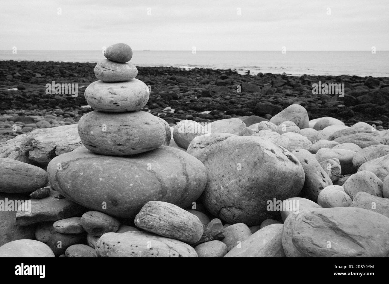 Pequeña torre de piedras en una playa con fondo fuera de foco Foto de stock