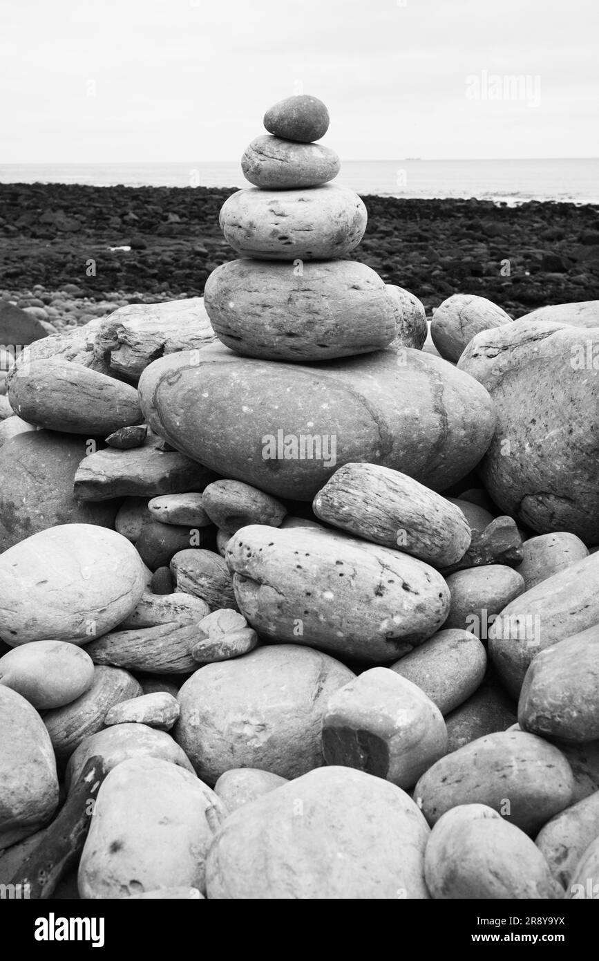Pequeña torre de piedras en una playa con fondo fuera de foco Foto de stock