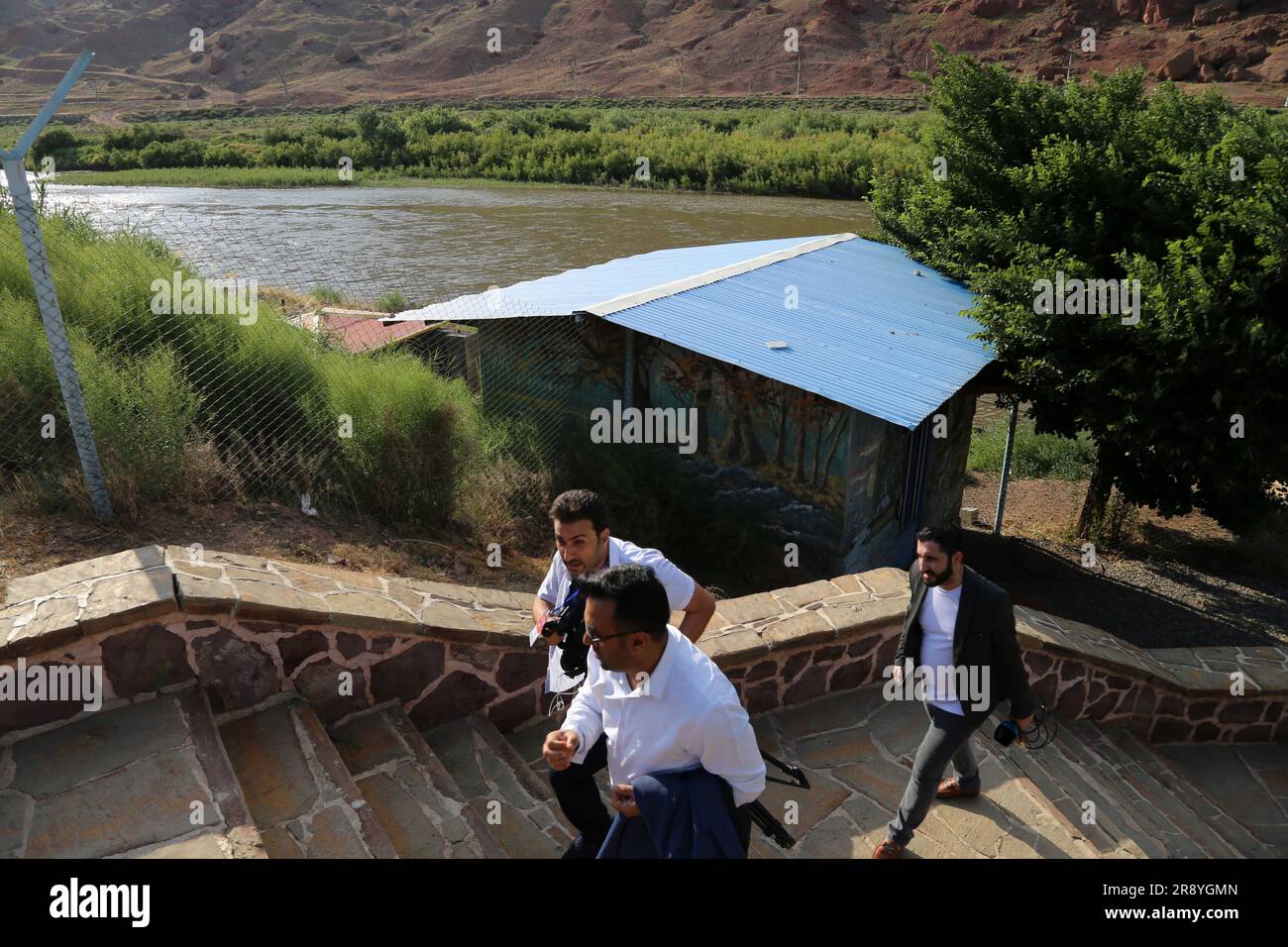 21 de junio de 2023, Jolfa, Azerbaiyán Oriental, Irán: Tres hombres caminan cerca del río Aras en la frontera entre el noroeste de Irán y Azerbaiyán. El Aras (los Araks, Arax, Araxes, o Araz) es un río en el Cáucaso. Se levanta en el este de Turquía y fluye a lo largo de las fronteras entre Turquía y Armenia, entre Turquía y el exclave de Najicheván de Azerbaiyán, entre Irán y Azerbaiyán y Armenia, y, finalmente, a través de Azerbaiyán, donde desemboca en el río Kura. Drena el lado sur de las montañas del Cáucaso Menor, mientras que el Kura drena el lado norte del Cáucaso Menor. El total del río Foto de stock