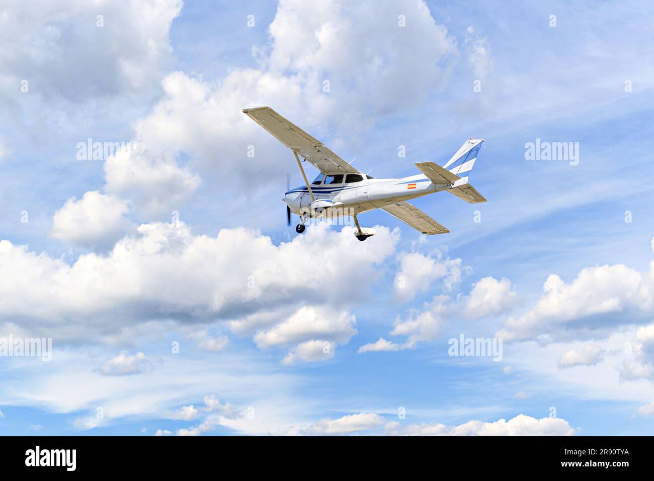 Avión ultraligero de un solo motor volando en el cielo azul con nubes blancas Foto de stock