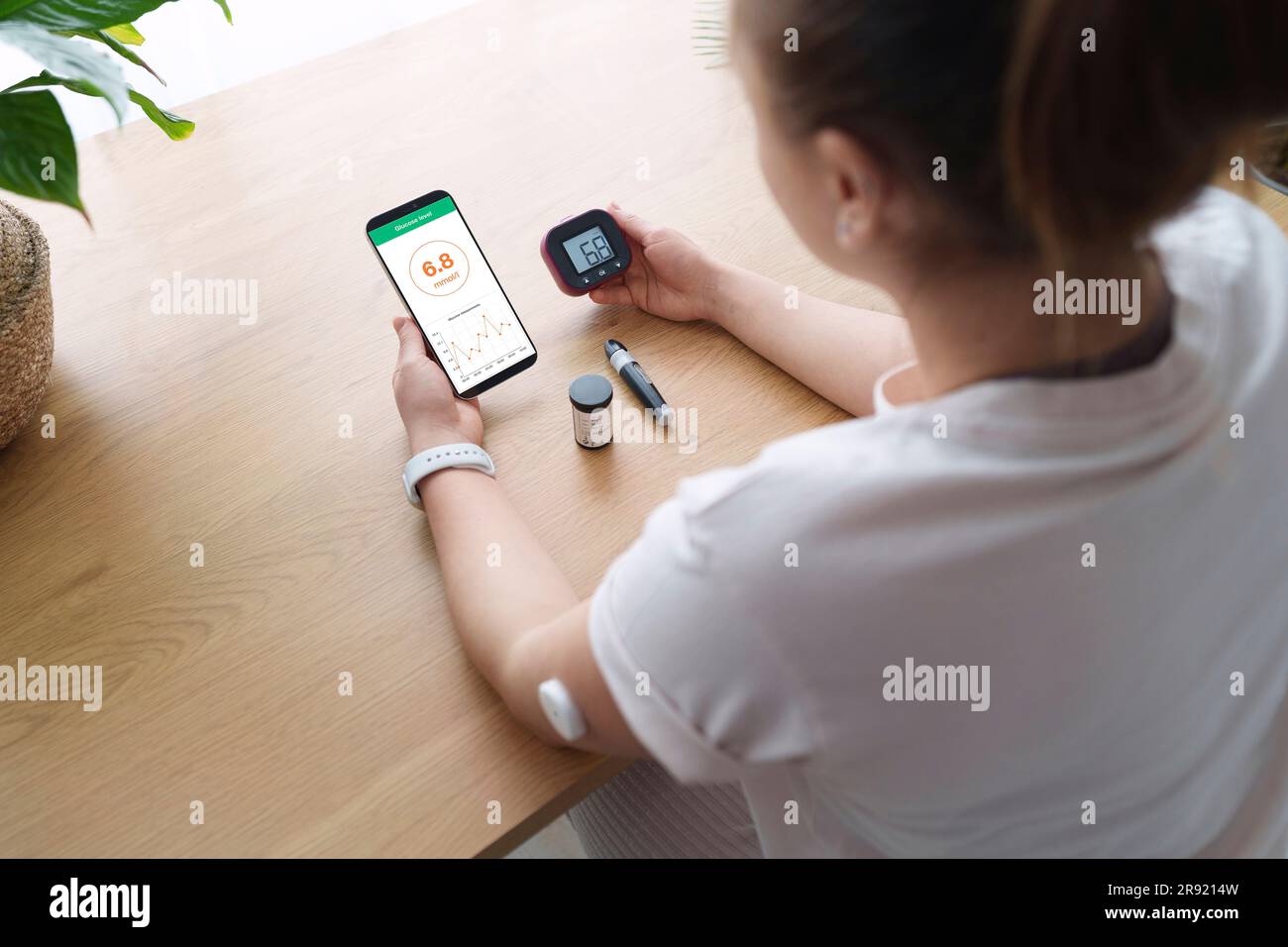 Mujer con diabetes que sincroniza el teléfono inteligente y el glucómetro  en casa Fotografía de stock - Alamy