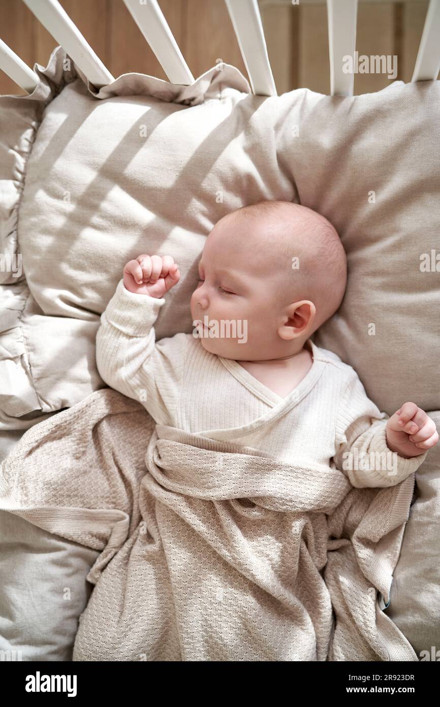 Bebé recién nacido niña relajada en calma dormida en una cesta blanca y  rosa sobre una manta de pelo Stock Photo