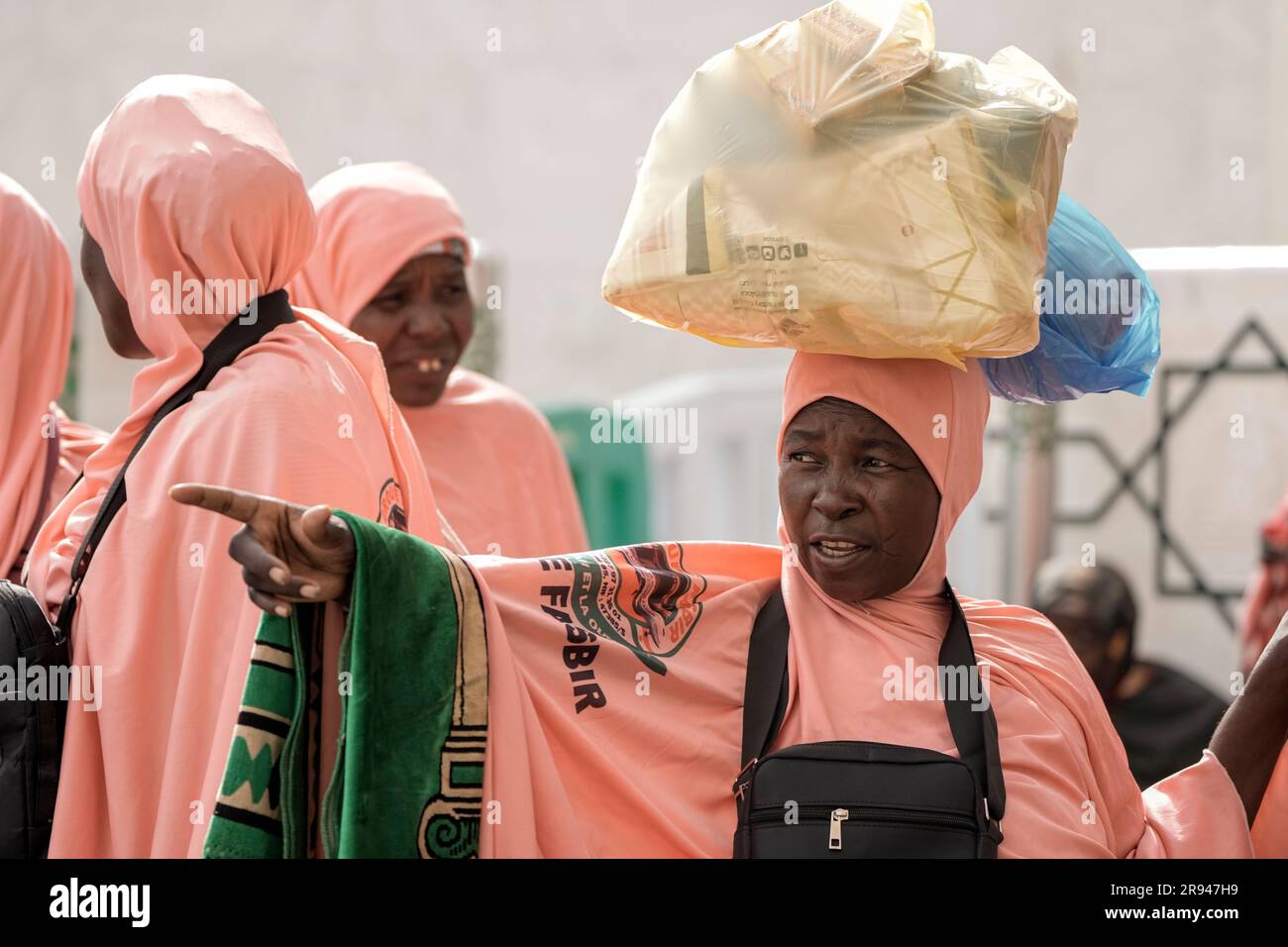 A Nigerian pilgrim carries her bags outside the Grand Mosque, during