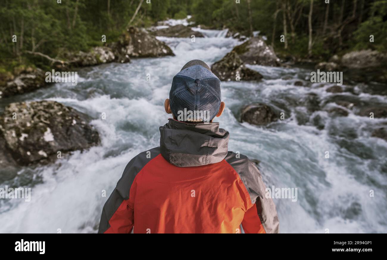 Hombre caucásico frente a Wilderness River y preparándose para la nueva aventura. Foto de stock