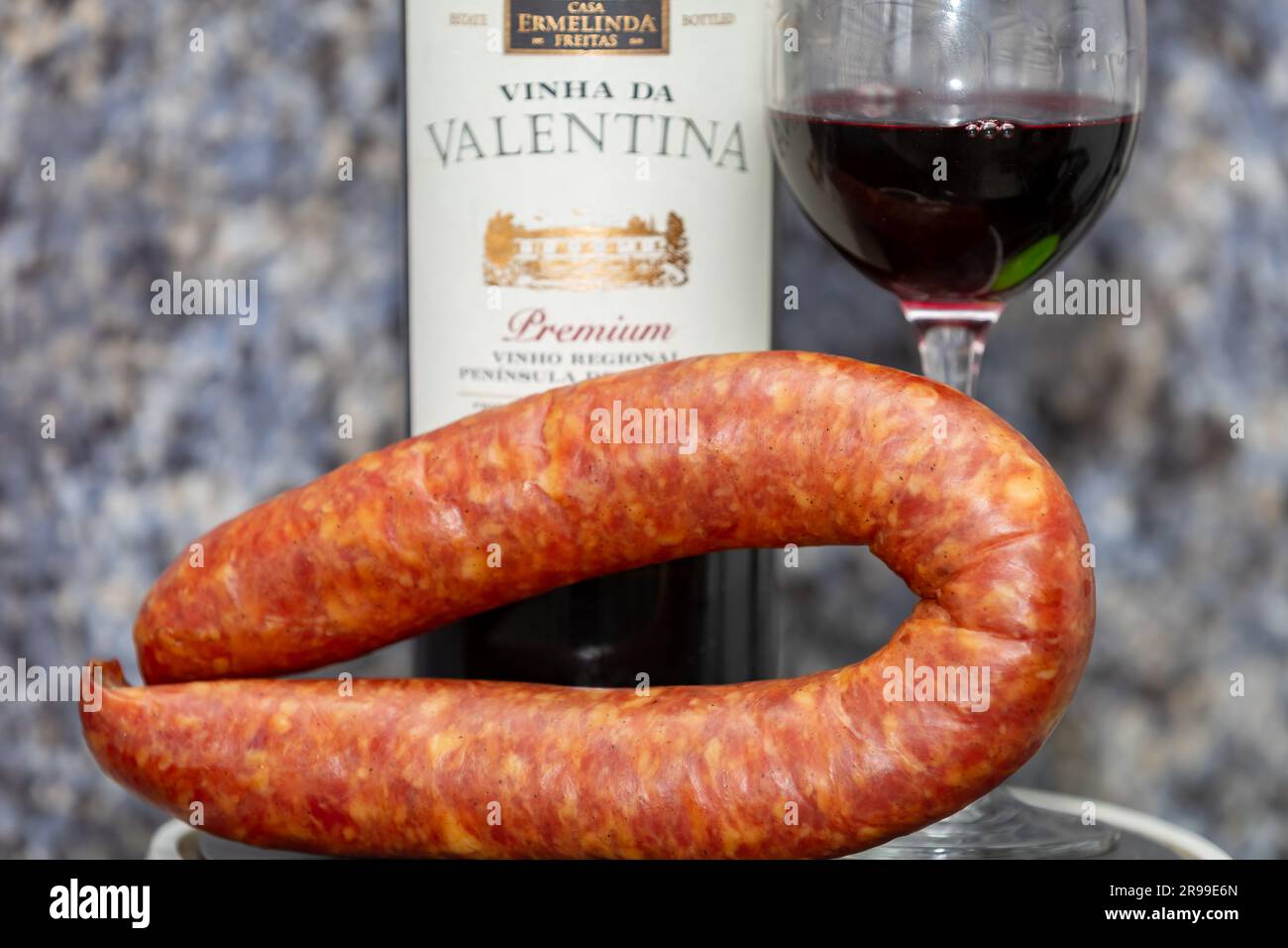 Típico salami colonial con botella de vino tinto y copa. Comida tradicional italiana. Foto de stock