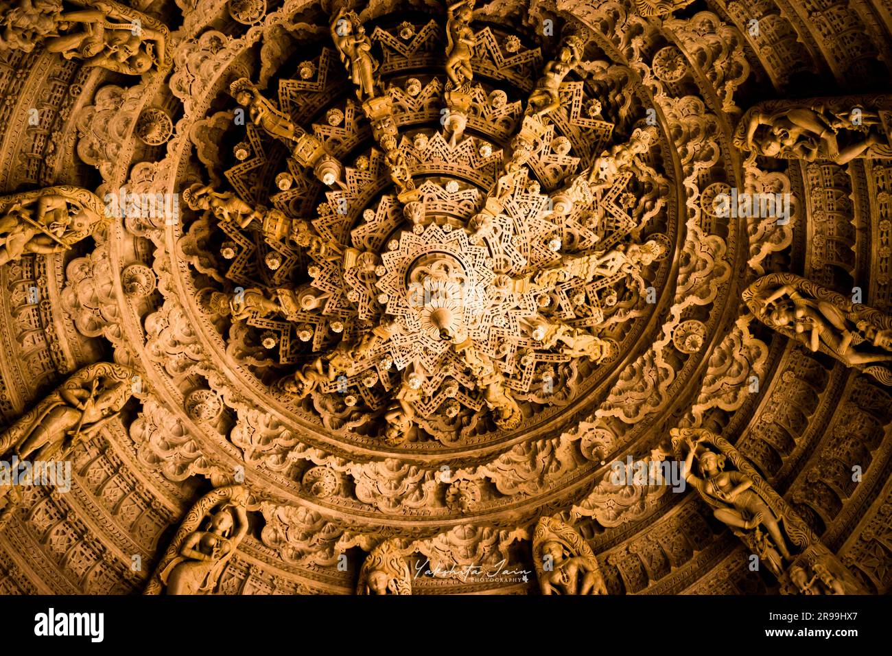 Un ángulo bajo de un techo de madera decorativo de una cúpula con tallas de Buda Foto de stock