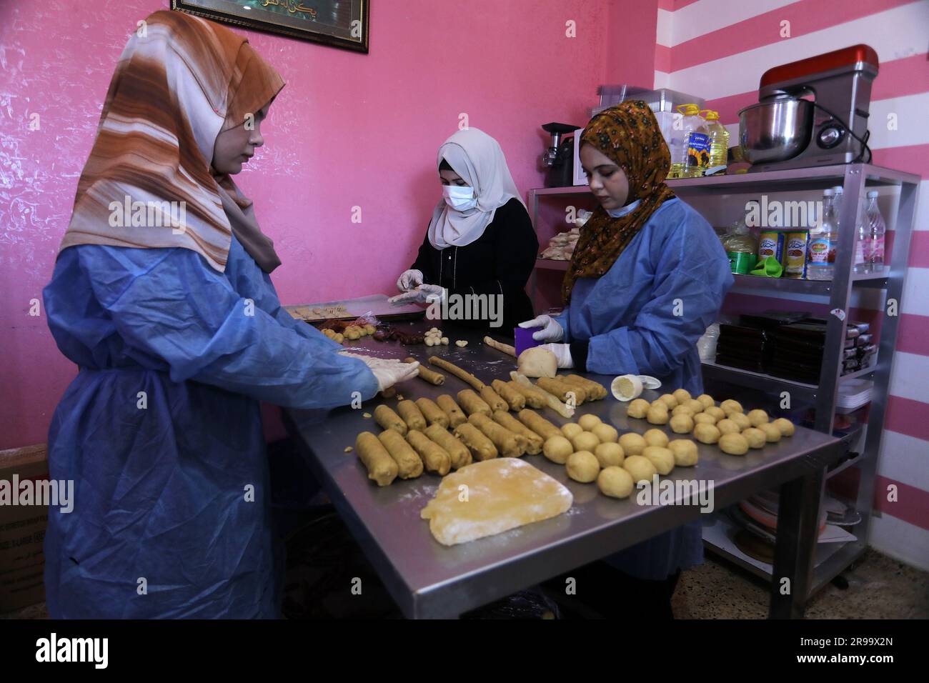 Mujeres palestinas hacen galletas llamadas 'Eid Cakes' antes de Eid Al-Adha, en su casa en la Franja de Gaza, el 25 de junio de 2023. Foto de stock