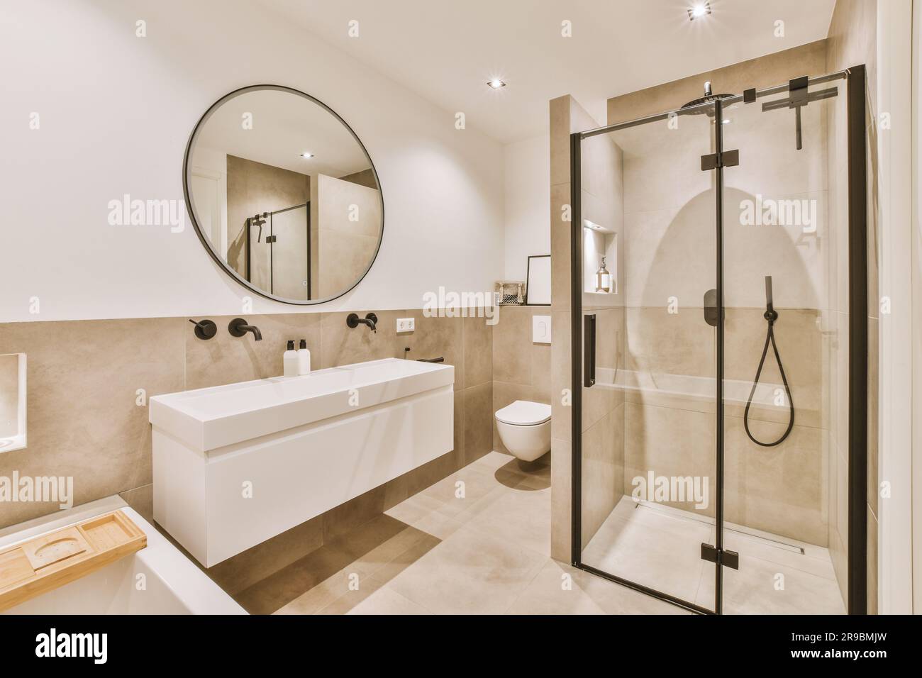 un cuarto de baño con ducha, lavabo e inodoro en la zona de esquina junto a  la bañera hay un espejo en la pared Fotografía de stock - Alamy