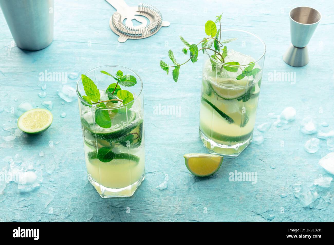 Cóctel Mojito, dos vasos. Bebida fría de verano con lima, menta fresca y  hielo. Bebida fresca sobre un fondo azul Fotografía de stock - Alamy