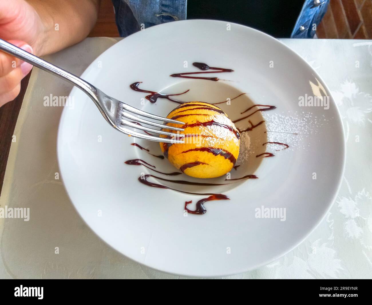 Cerca de helado frito decorado en un plato blanco con un tenedor en la  mano. Posición plana, vista superior. Postre típico chino Fotografía de  stock - Alamy