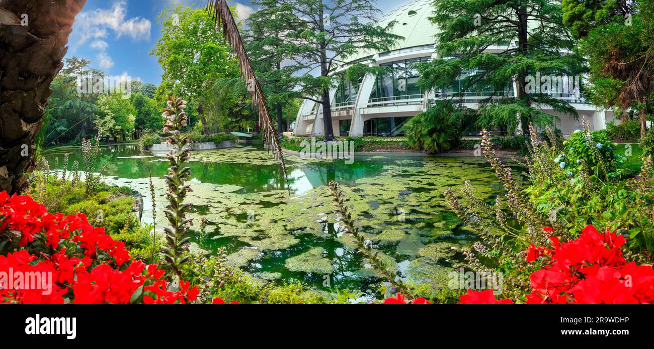 Vista panorámica de un jardín de flores con un lago en el medio, y el pabellón del Palacio de Cristal en el fondo en Oporto, Portugal Foto de stock